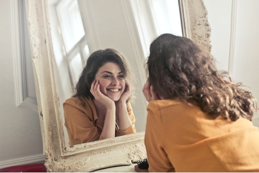 A person looking in a mirror and smiling